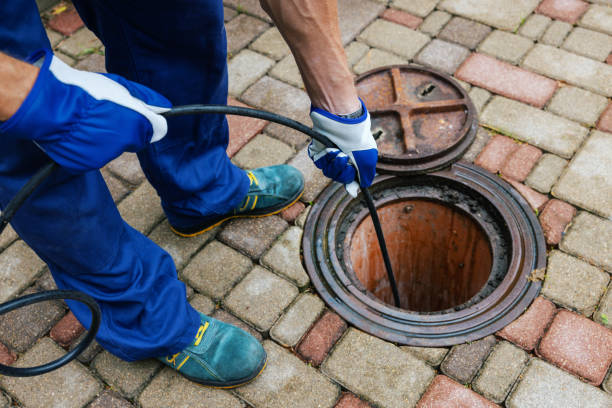 A worker cleaning a clogged drain with hydro jetting